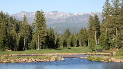 a golf course with a lake and mountains in the background at Donner Gem by Tahoe Getaways - Beautifully Updated, Hot Tub, Pet Friendly in Truckee