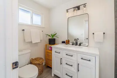a bathroom with a sink and a toilet and a mirror at Cozy Family Haven in Sparks - Pet Friendly - Fenced Yard in Sparks