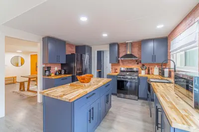 a large kitchen with blue cabinets and wooden counter tops at Cozy Family Haven in Sparks - Pet Friendly - Fenced Yard in Sparks