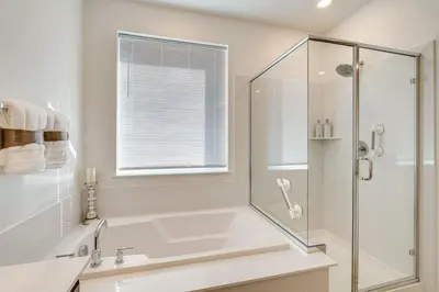 a bathroom with a tub and a glass shower at 15 Mi to Dtwn Sacramento Newly Built Home! in Sacramento