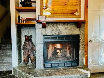 a stone fireplace with a bear statue next to it at Cozy Bear South-Inside Yosemite-Sleeps 5 in Yosemite West