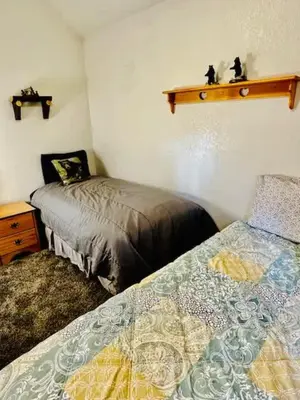 a bedroom with two beds and a table and a shelf at Cozy Bear South-Inside Yosemite-Sleeps 5 in Yosemite West