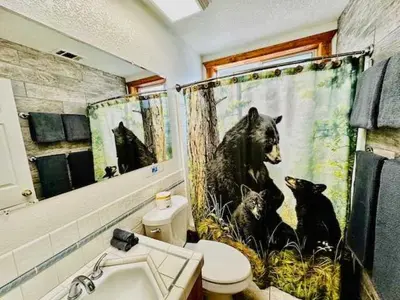 a bathroom with a black bear shower curtain at Cozy Bear South-Inside Yosemite-Sleeps 5 in Yosemite West