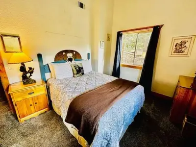 a bedroom with a bed and a lamp and a window at Cozy Bear South-Inside Yosemite-Sleeps 5 in Yosemite West
