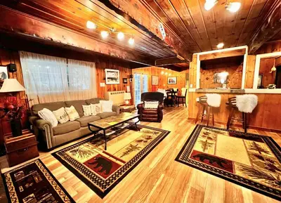 a living room with a couch and a table at Cozy Yosemite Cabin with Hot Tub in the Pines in Fish Camp