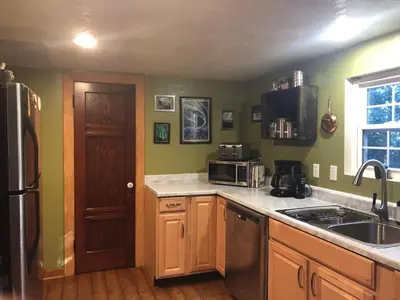 a kitchen with a sink and a refrigerator at Cozy Yosemite Cabin with Hot Tub in the Pines in Fish Camp