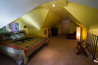 a bedroom with a bed in a room with an attic at Cozy Yosemite Cabin with Hot Tub in the Pines in Fish Camp