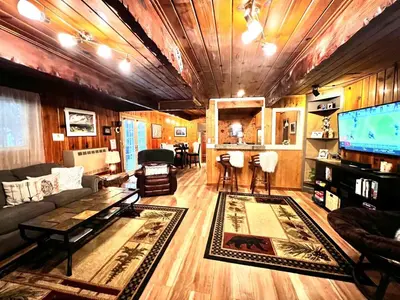 a living room with a couch and a tv at Cozy Yosemite Cabin with Hot Tub in the Pines in Fish Camp