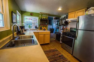 a kitchen with a sink and a stainless steel refrigerator at Cozy Yosemite Cabin with Hot Tub in the Pines in Fish Camp