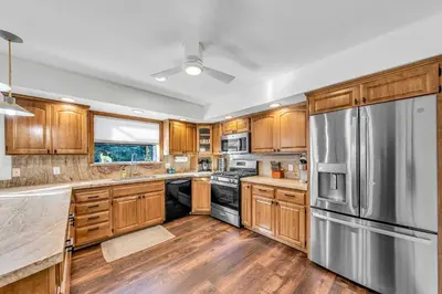 a kitchen with wooden cabinets and a stainless steel refrigerator at Tahoe Retreat with Decks and Separate Studio in Tahoe Vista