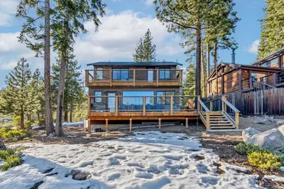 a house in the woods in the snow at Cozy Carnelian Bay Vacation Rental with Lake Views in Carnelian Bay