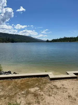 a large body of water with a dock on the shore at Wishon Lake Front, Price Reduced, 3day Min in Bass Lake