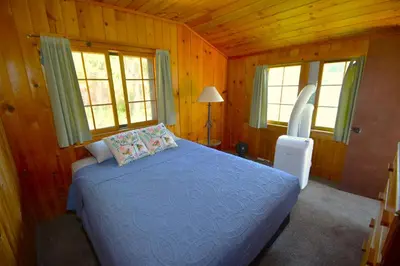 a bedroom with a blue bed in a wooden room at Wishon Lake Front, Price Reduced, 3day Min in Bass Lake