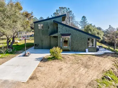 a sustainable house with a black roof at Rocky Ridge Cabin Yosemite in Coarsegold