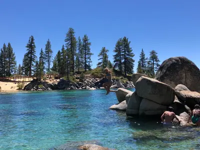 a group of people jumping off rocks into a river at Zephyr Cove first level 1 Bed: close to everything bike, ski, swim! in Zephyr Cove