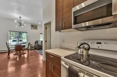 a kitchen with a stove top oven next to a table at Zephyr Cove first level 1 Bed: close to everything bike, ski, swim! in Zephyr Cove
