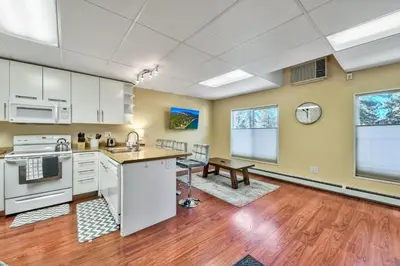 an open kitchen with white cabinets and a wooden floor at First level studio suite close to everything bike, ski, swim Zephyr Cove! in Zephyr Cove