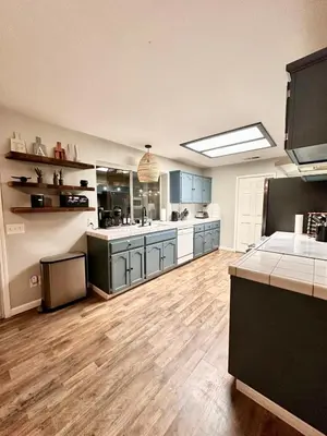 a large kitchen with blue cabinets and wooden floors at Yosemite Vista Highlands in Oakhurst