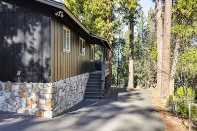 a building with a stone wall next to a path at Access to Pine Mountain Lake Family Cabin with Deck in Groveland