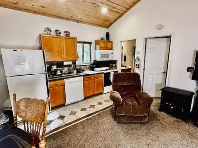 a kitchen with a white refrigerator and a chair at Yosemite Woods Duplex in Yosemite-Upper Unit in Yosemite West