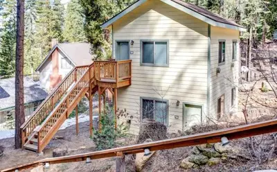 a house with a wooden deck in the woods at Yosemite Woods Duplex in Yosemite-Upper Unit in Yosemite West