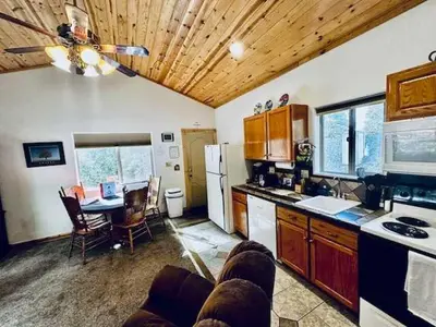 a kitchen and dining room with a table and a refrigerator at Yosemite Woods Duplex in Yosemite-Upper Unit in Yosemite West