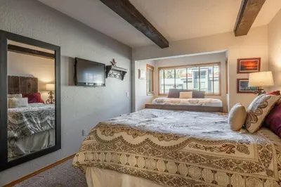 a bedroom with a large bed and a mirror at Canyon Slopeside Retreat in Mammoth Lakes
