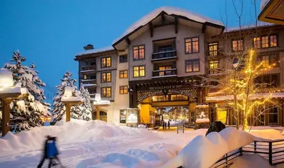 a building with snow on the ground in front of it at Palisades Village ski in ski out Mountain Retreat in Olympic Valley