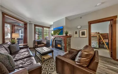 a living room with a couch and a fireplace at Palisades Village ski in ski out Mountain Retreat in Olympic Valley