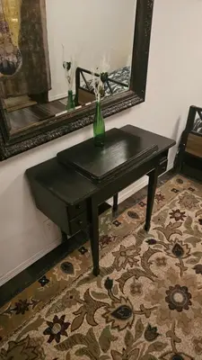 a black table with a vase on it in front of a mirror at The Secret Hideaway in Oakhurst