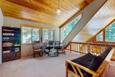 a living room with a table and a balcony at Evergreen Escape in Truckee
