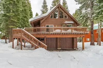a log cabin in the snow with a large deck at Evergreen Escape in Truckee