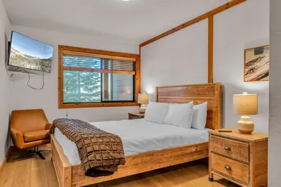 a bedroom with a bed and a chair and a window at Cozy Mountain Retreat in Truckee Near Northstar in Truckee