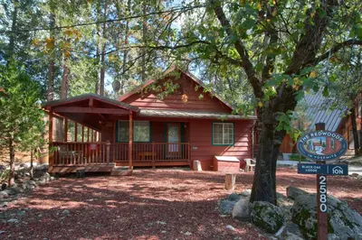 a small red cabin with a sign in front of it at Black Oak Lodge at The Redwoods in Wawona