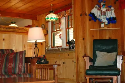 a living room with a chair and a table at Black Oak Lodge at The Redwoods in Wawona