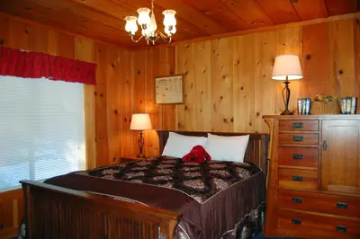 a bedroom with a bed and two lamps and a dresser at Black Oak Lodge at The Redwoods in Wawona
