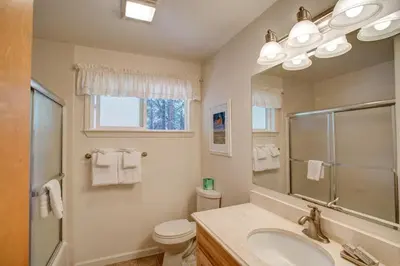 a bathroom with a sink and a toilet and a mirror at Sequoia House at The Redwoods in Wawona