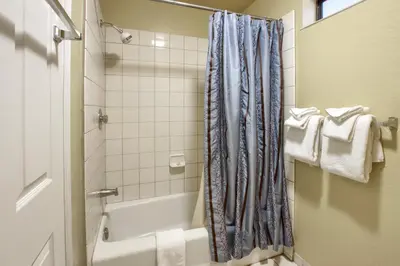 a bathroom with a shower curtain and a tub at Cabin Among the Firs in Wawona