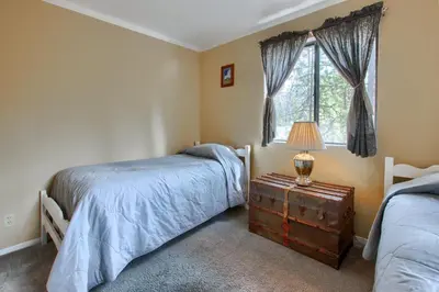 a bedroom with two beds and a table with a lamp at Cabin Among the Firs in Wawona