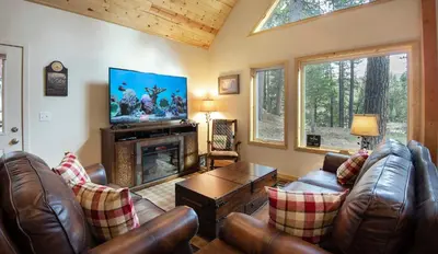 a living room with leather furniture and a fireplace at Margaret's at The Redwoods in Wawona