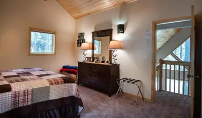 a bedroom with a bed and a dresser and a mirror at Margaret's at The Redwoods in Wawona
