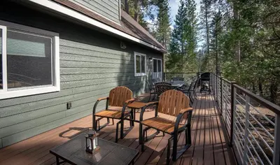 a deck with chairs and tables on a house at Margaret's at The Redwoods in Wawona