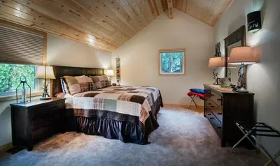 a bedroom with a bed and a desk and a window at Margaret's at The Redwoods in Wawona