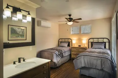 a bathroom with two beds and a sink and a mirror at Spring Meadow Retreat in Wawona