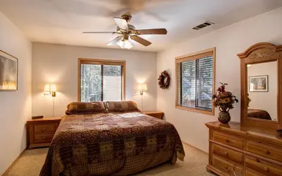 a bedroom with a bed and a ceiling fan at Cabin Twelve in Wawona