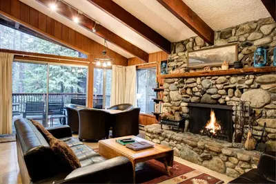 a stone fireplace in a living room with leather furniture at Star Gazers in Wawona