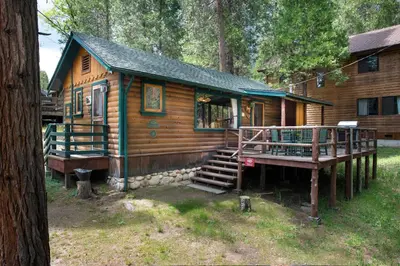 a log cabin with a porch and a deck at Chipmunk Hollow in Wawona
