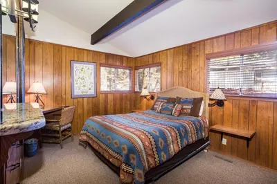 a bedroom with wooden walls and a bed and a desk at The Legacy in Wawona
