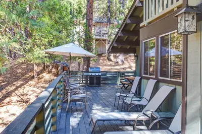 a deck with chairs and an umbrella on a house at The Legacy in Wawona
