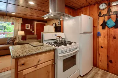 a kitchen with a white stove and a refrigerator at Chipmunks Holiday in Wawona